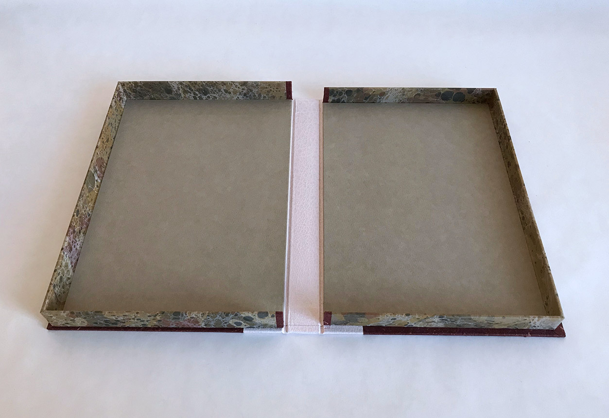 Box interior of Chemins De Traverse binding on a white table.