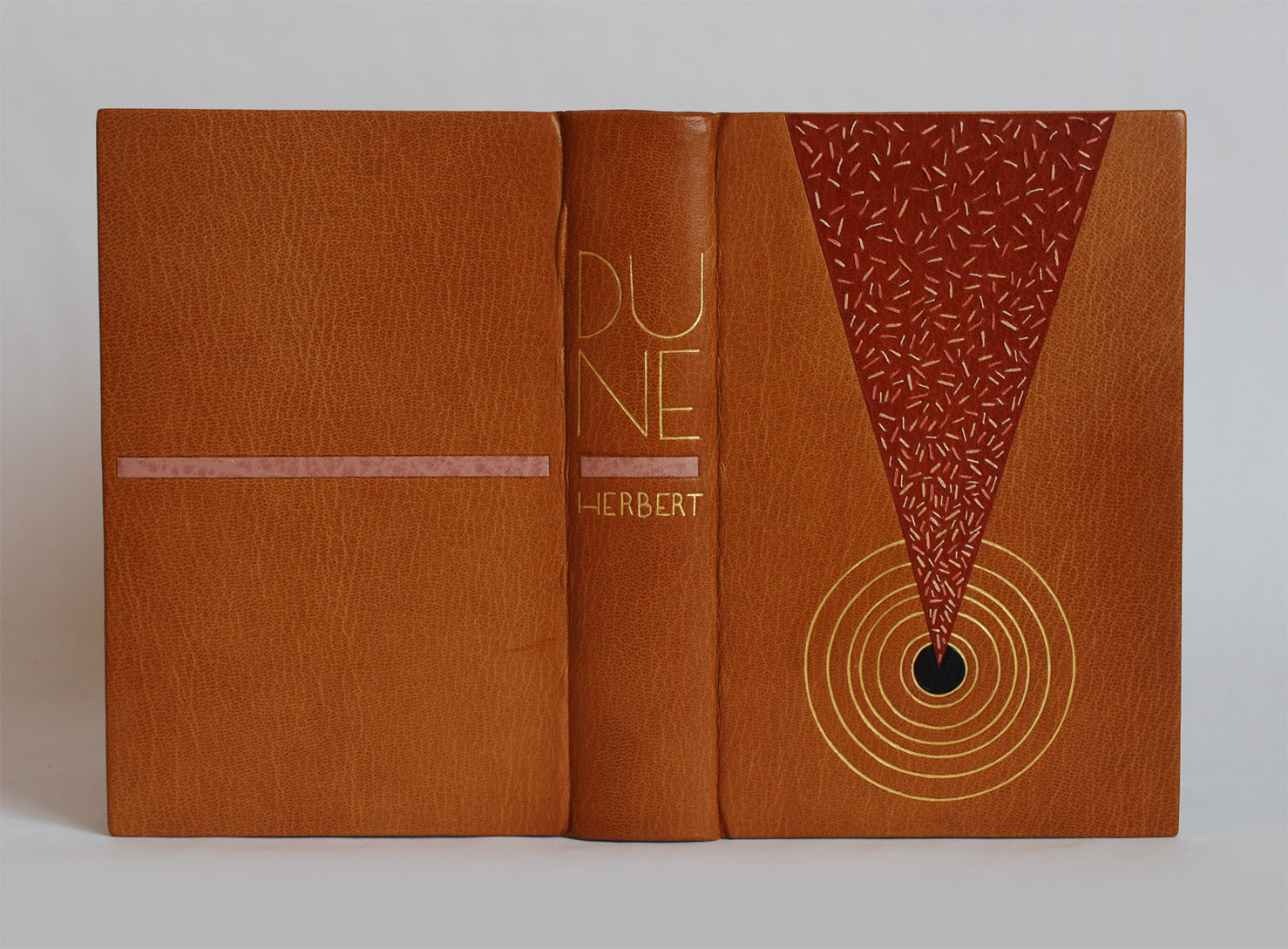 Front cover of Dune binding on a white table.