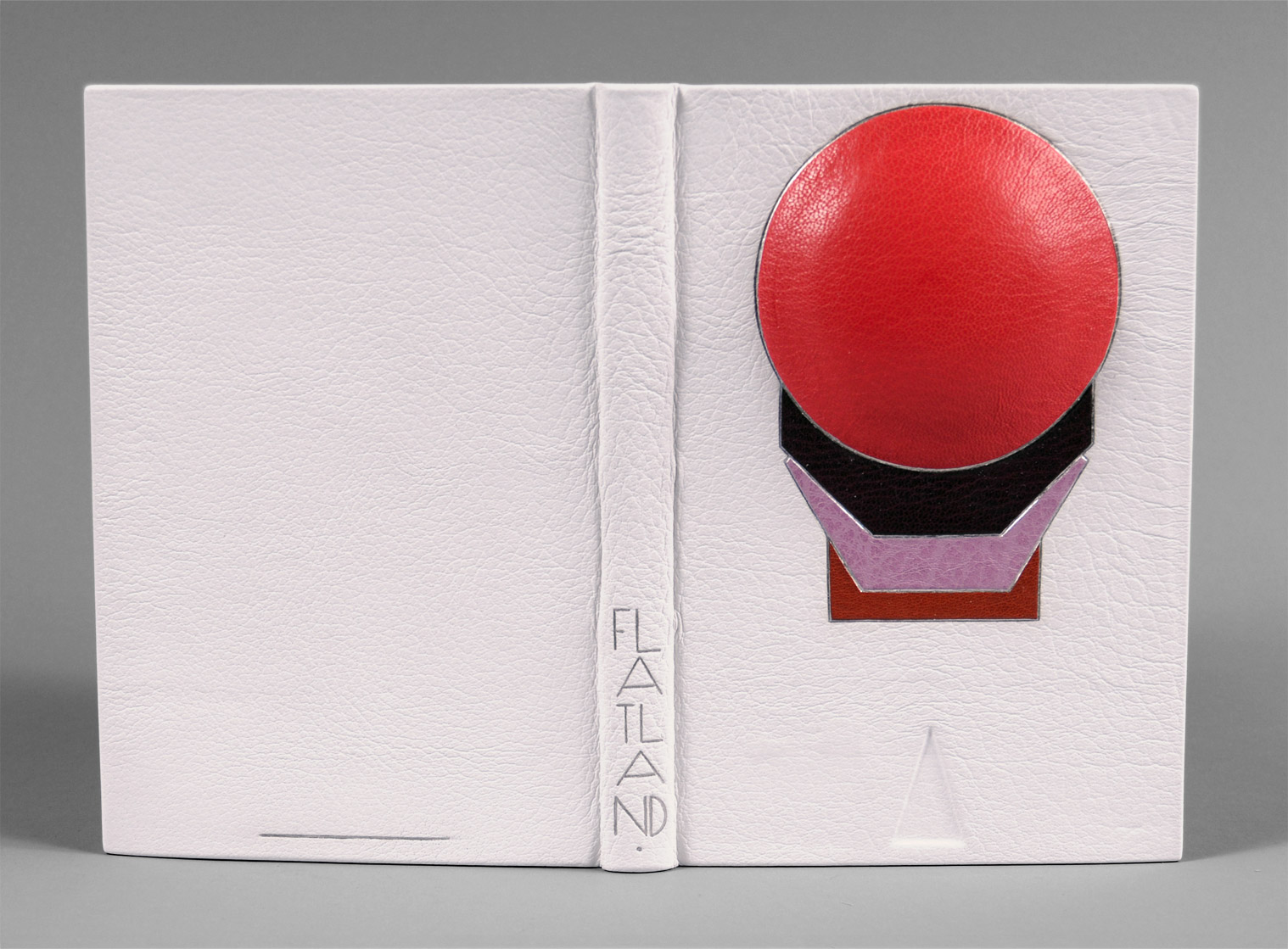 Front cover of Flatland: A Romance of Many Dimensions binding on a white table.