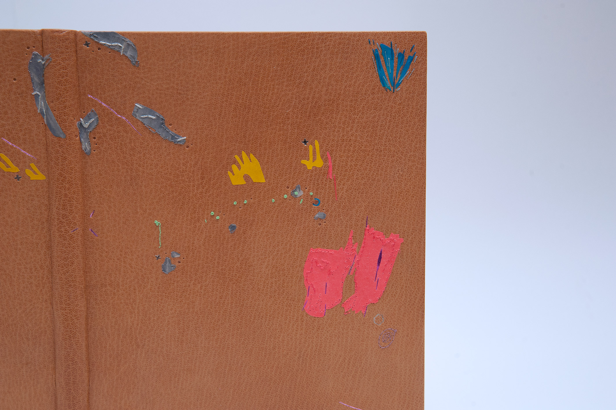 Close-up of front cover of Happy Abstract binding on a white table.