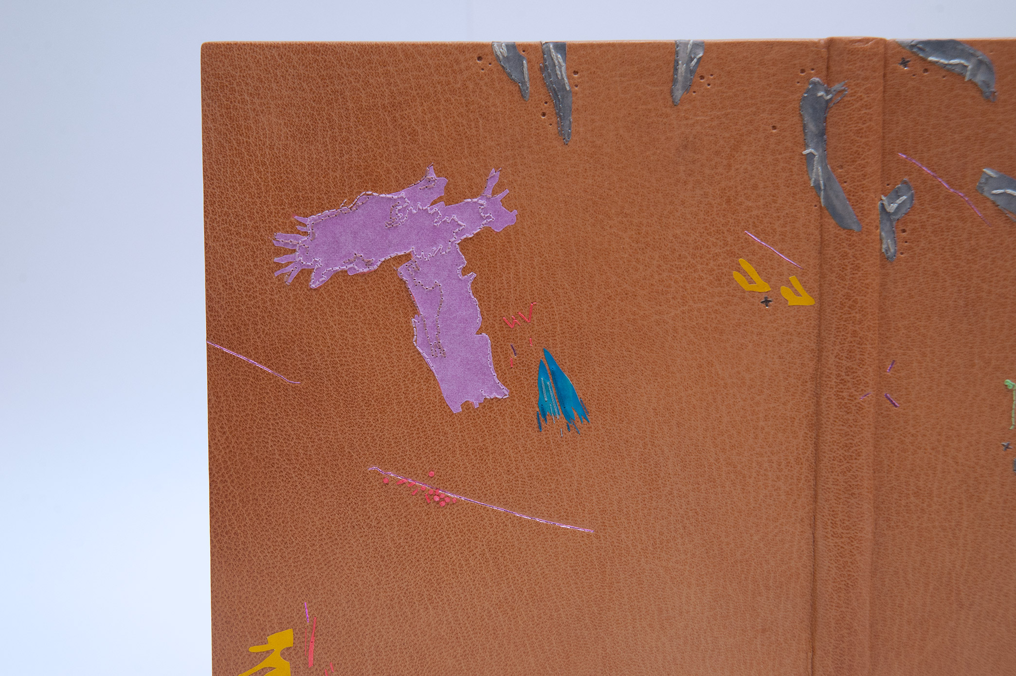 Close-up of front cover of Happy Abstract binding on a white table.