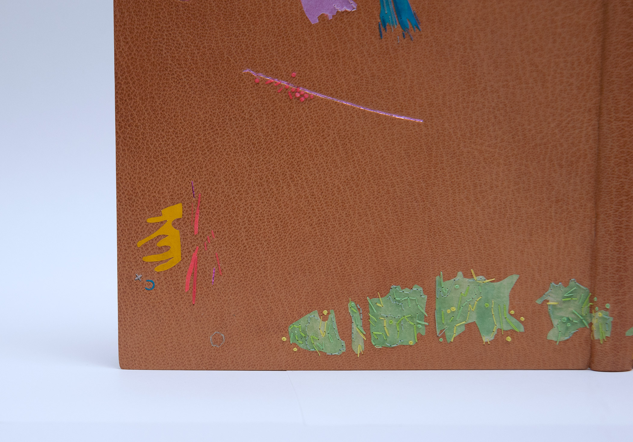 Close-up of front cover of Happy Abstract binding on a white table.