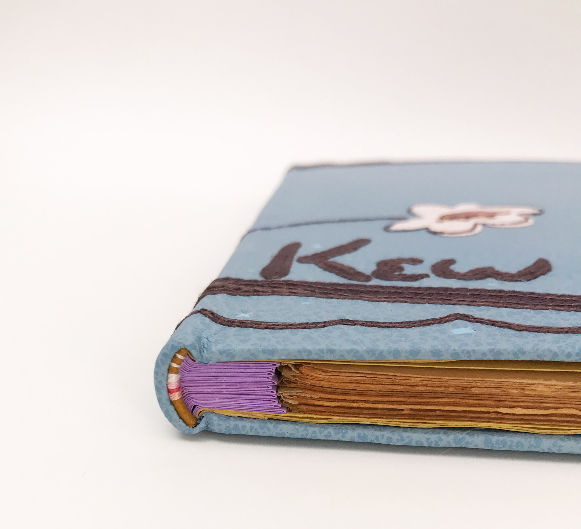 Edge of Kew Gardens binding on a white table.