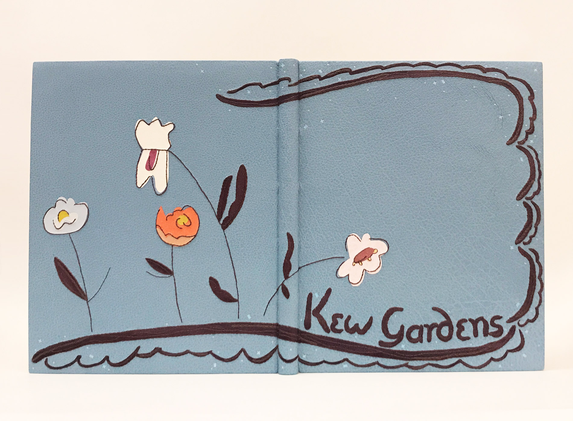 Front cover of Kew Gardens binding on a white table.