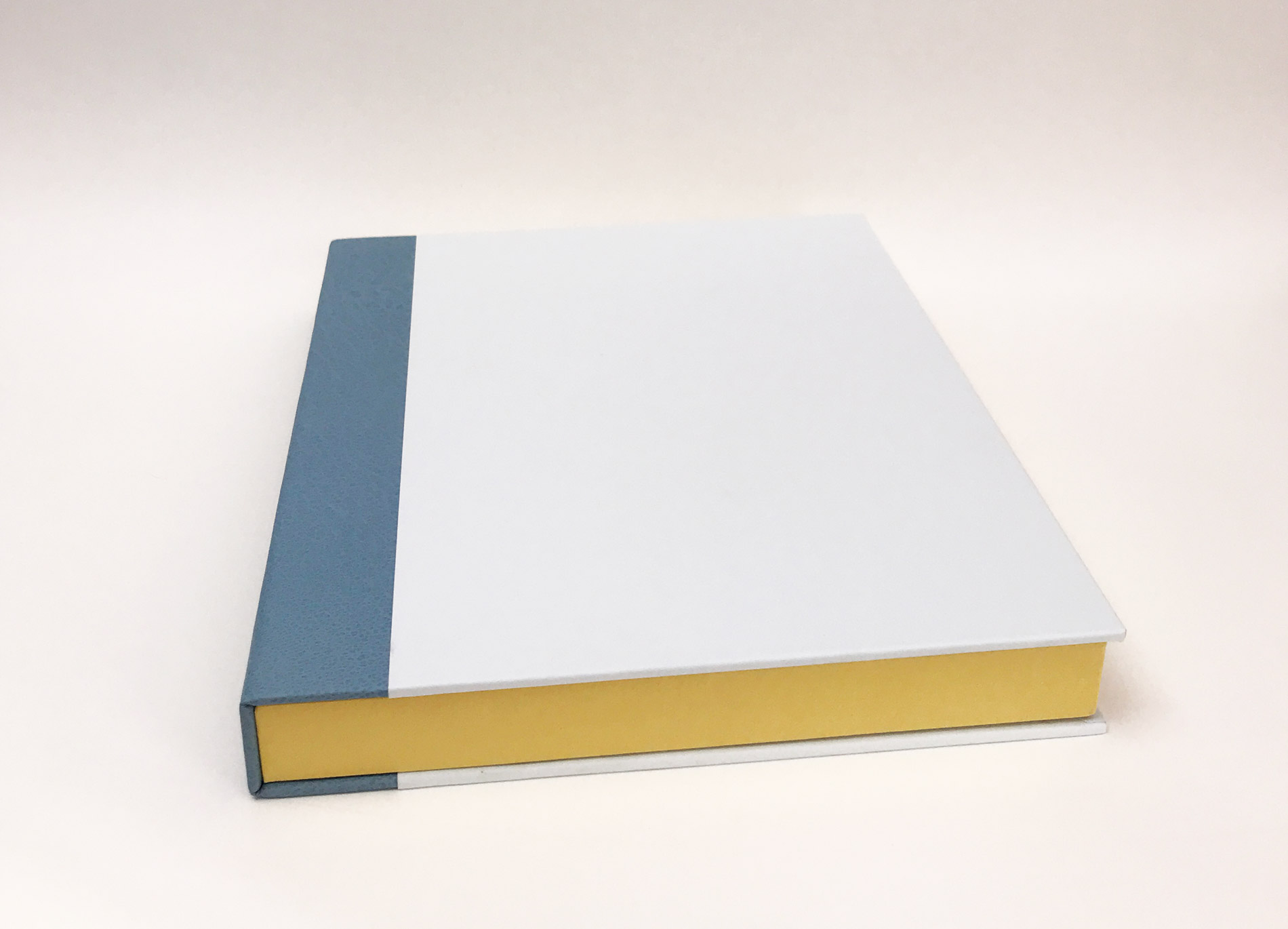 Box front cover of Kew Gardens binding on a white table.