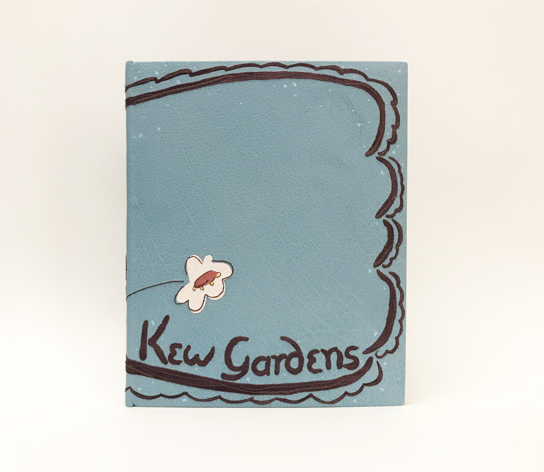 Front cover of Kew Gardens binding on a white table.