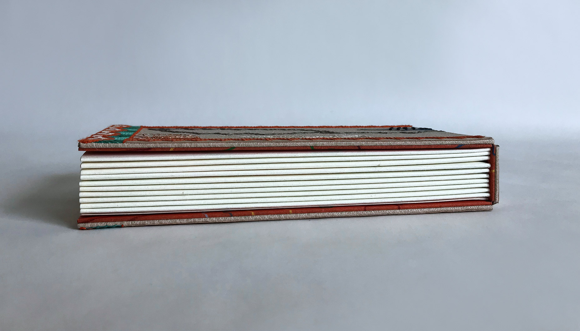 Edge of La Prose du Transsibérien binding on a white table.