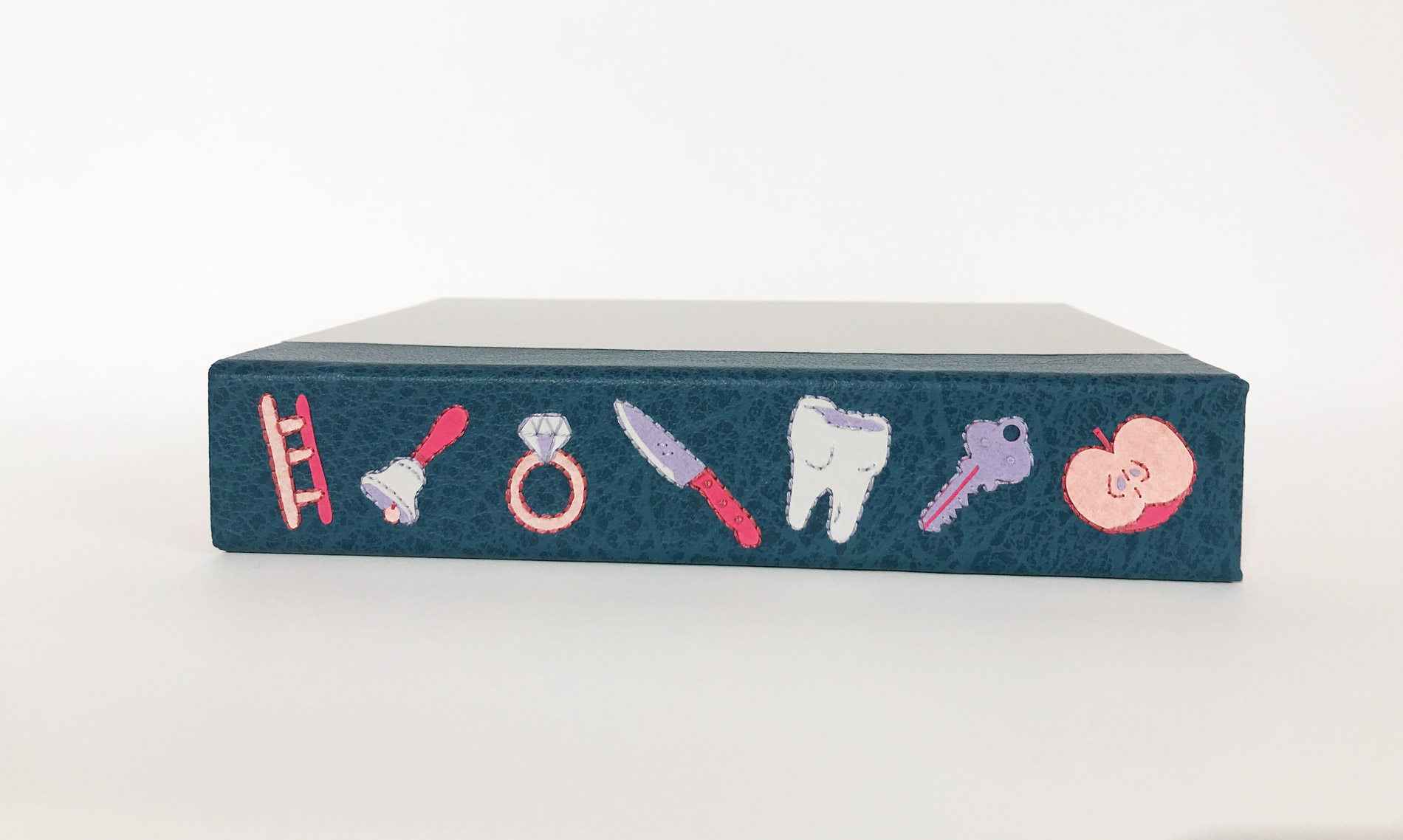Box spine of Le Palais Des Curieux binding on a white table.