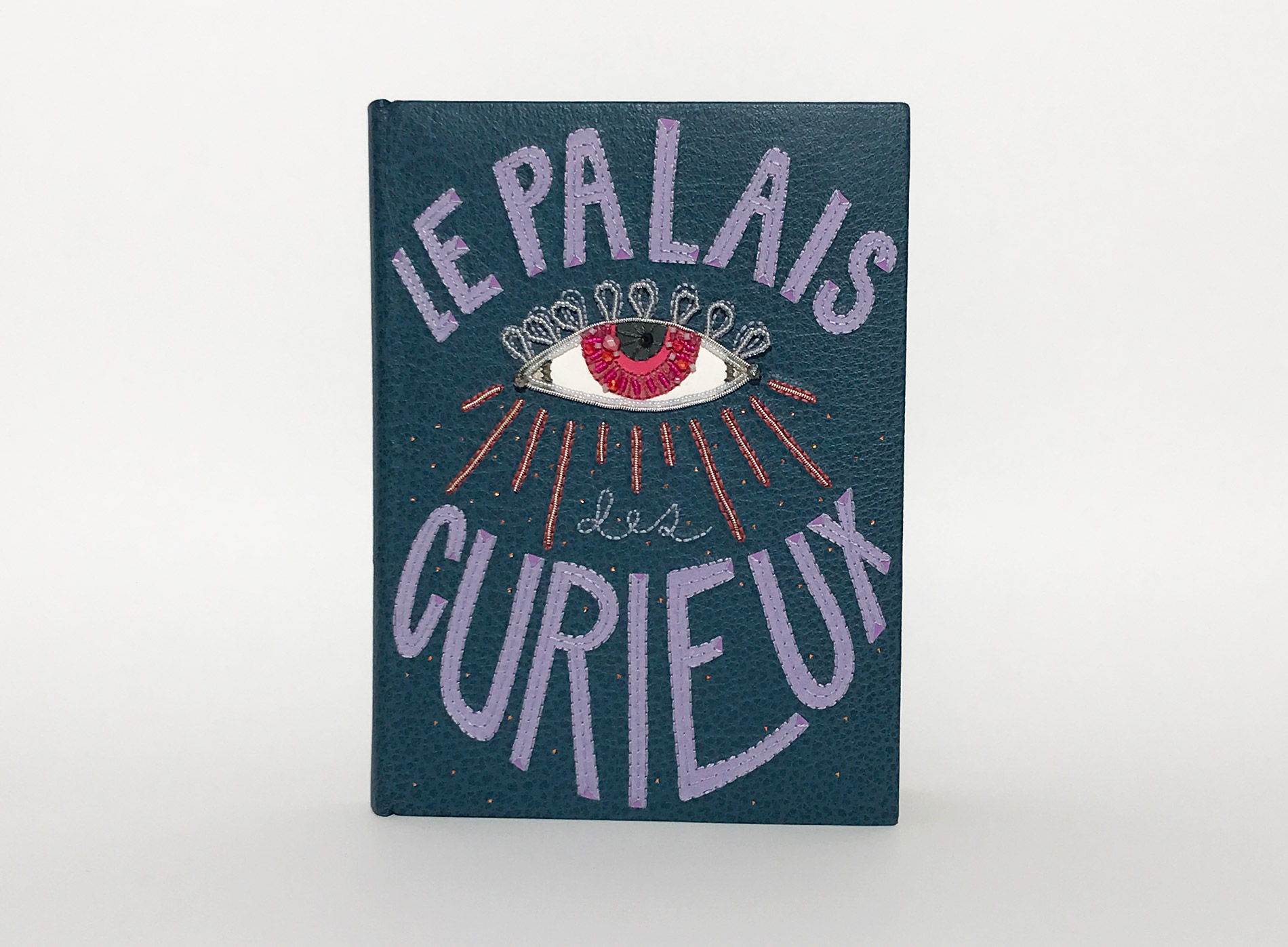 Front cover of Le Palais Des Curieux binding on a white table.