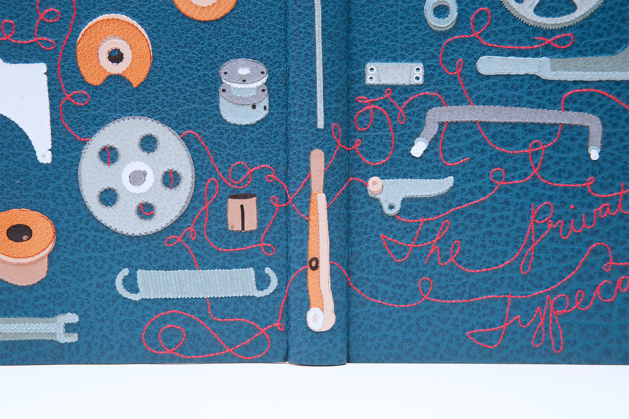 Close-up of front cover of The Private Typecasters binding on a white table.