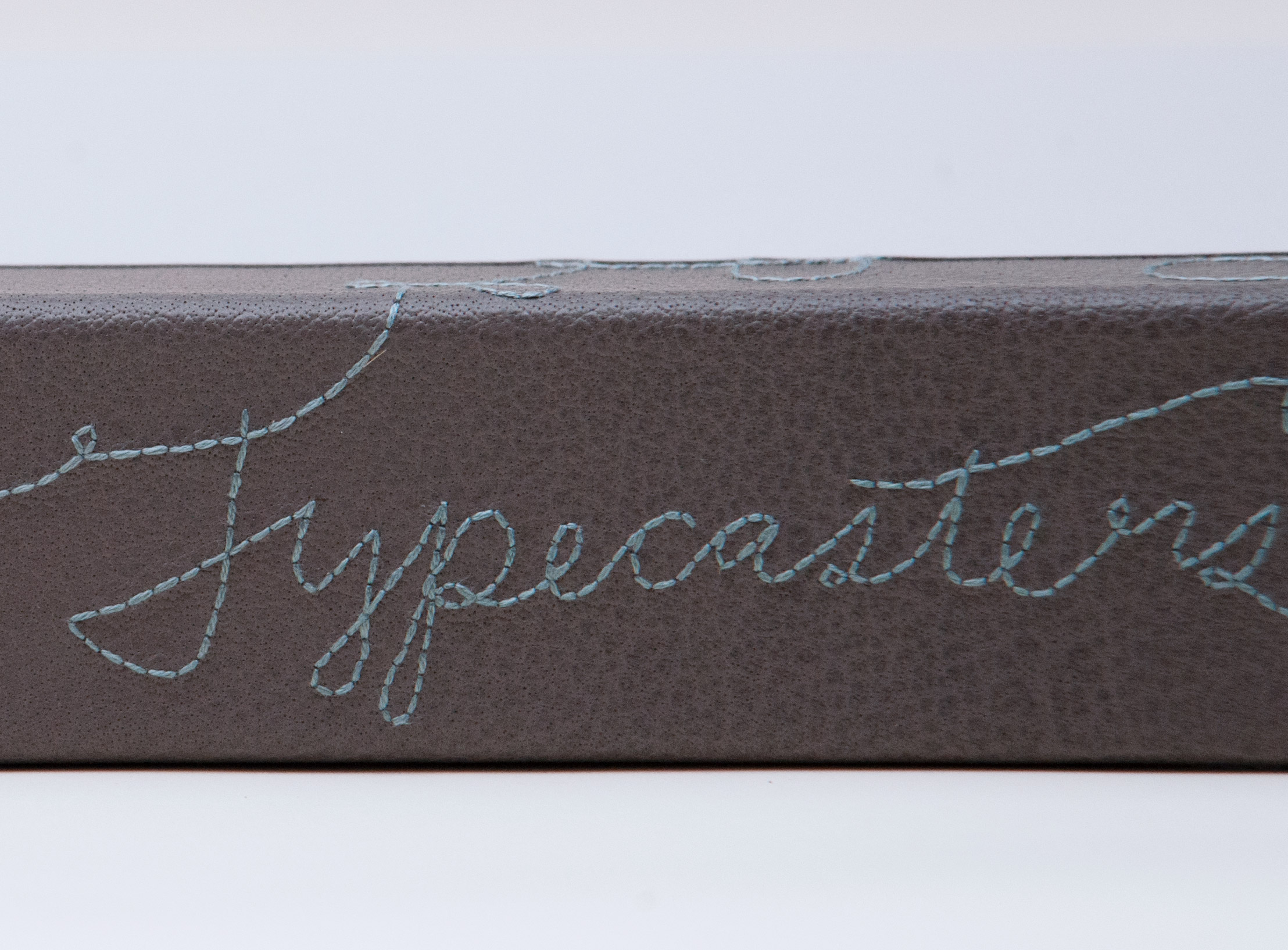 Close-up of box spine of The Private Typecasters binding on a white table.