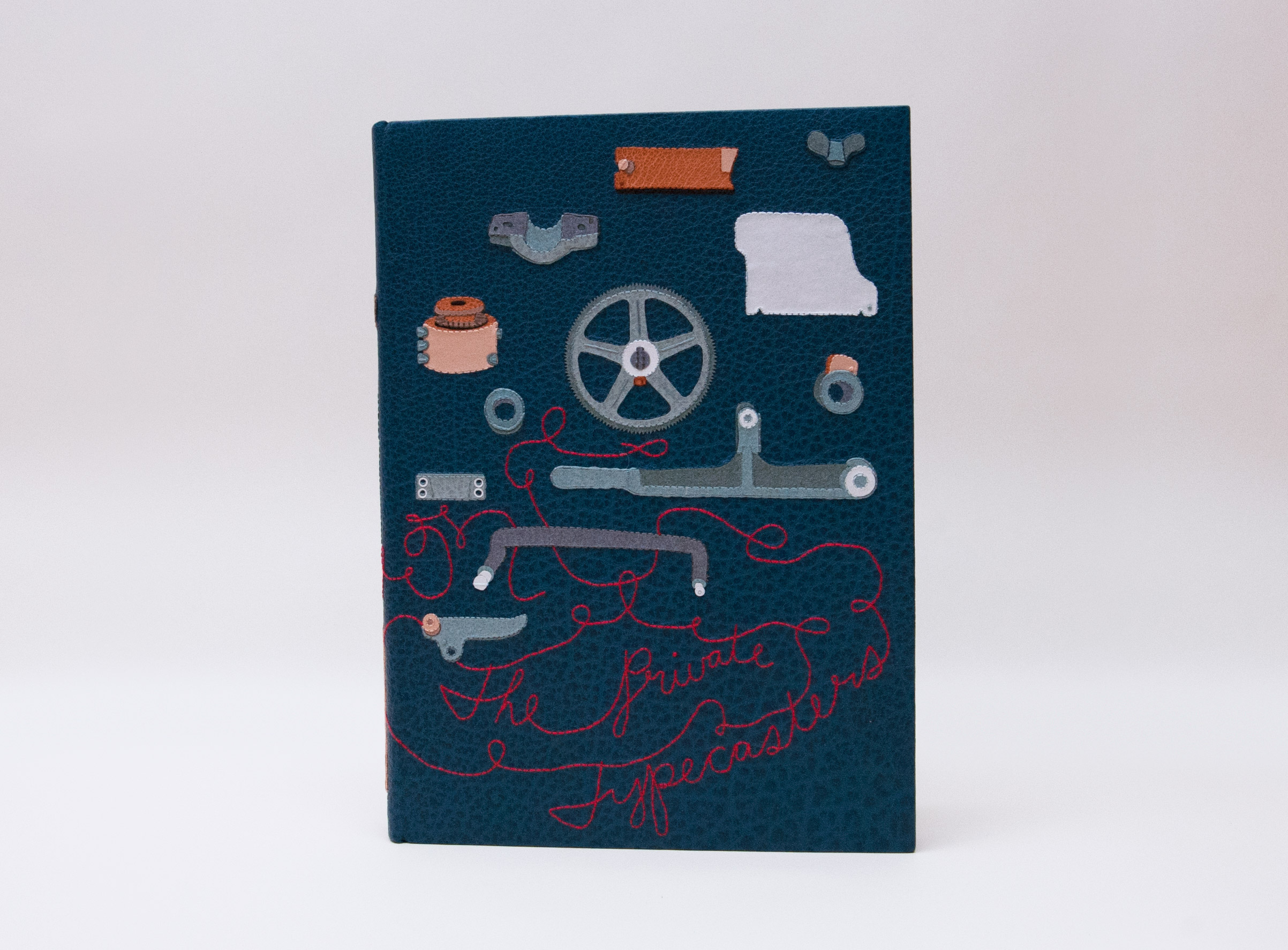 Front cover of The Private Typecasters binding on a white table.