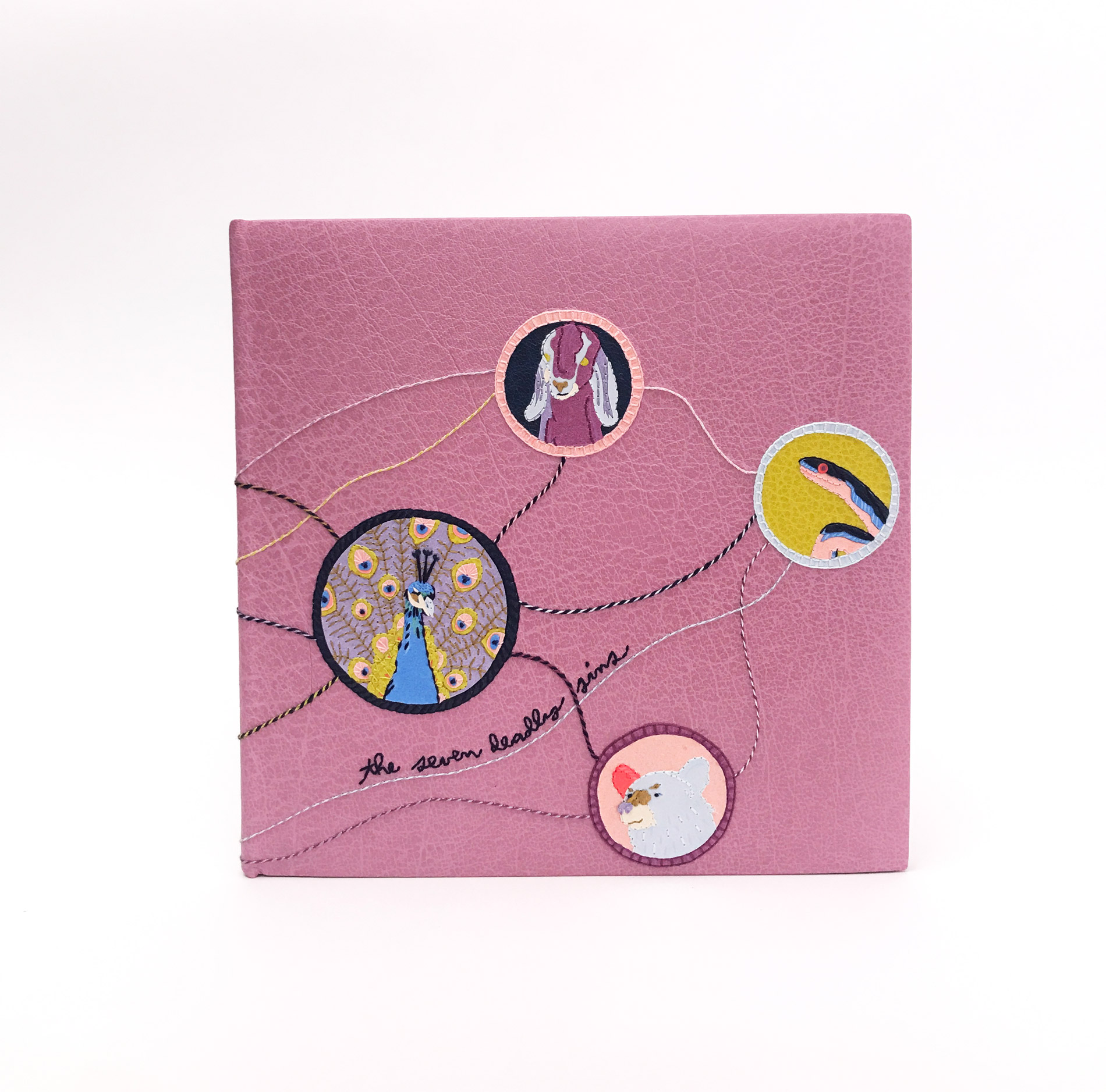 Front cover of The Seven Deadly Sins binding on a white table.
