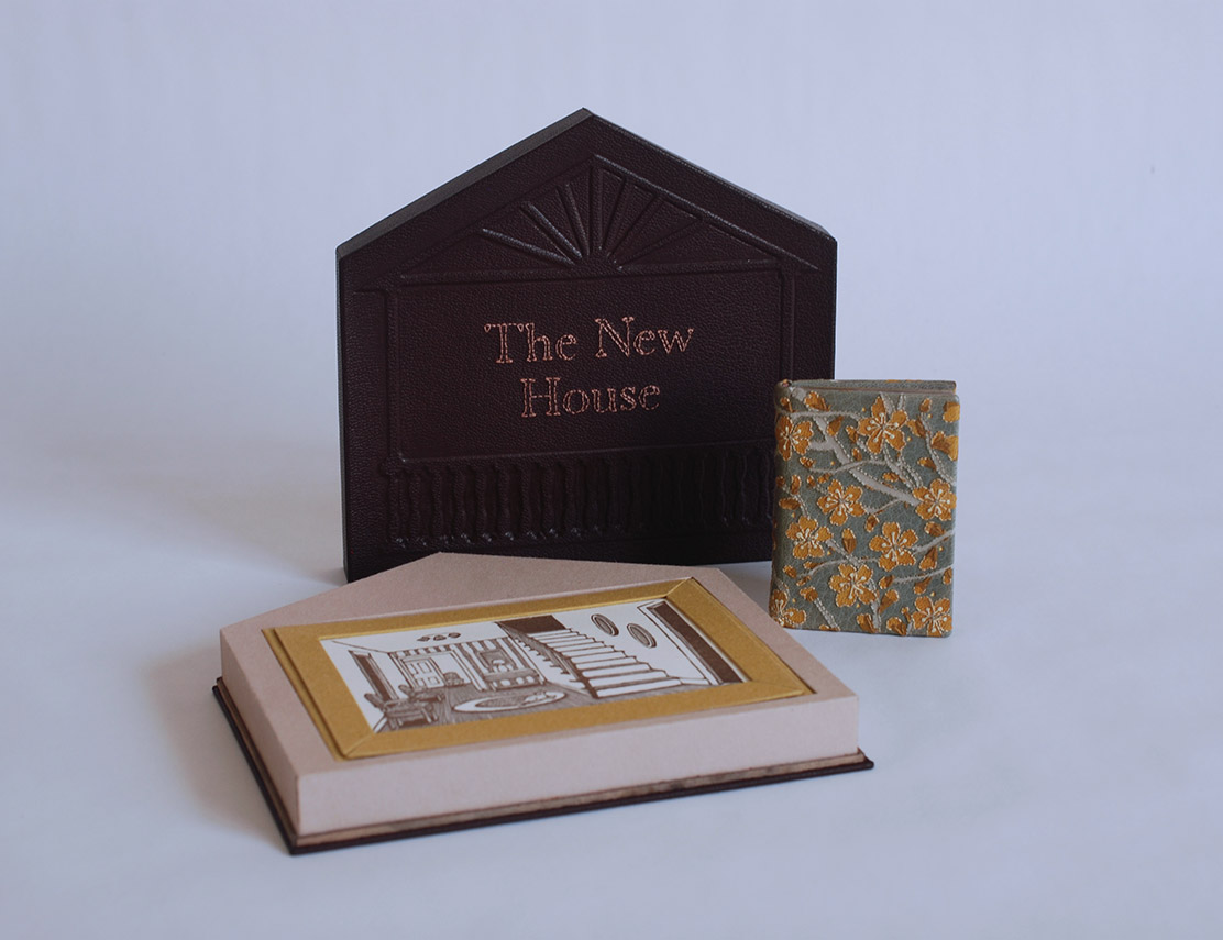 Box interior, print, and The New House binding on a white table.