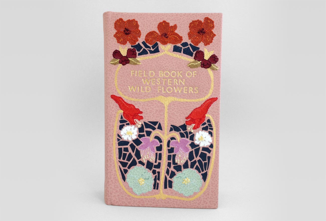 Front cover of Field Book of Western Wild Flowers binding on a white table.
