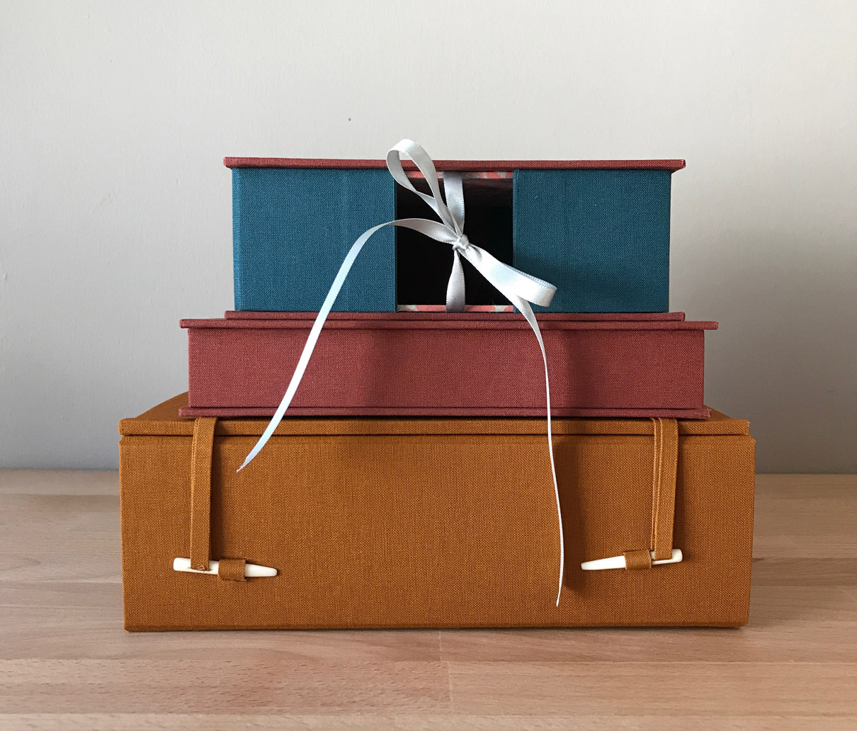 French-Tray with Drop Spine, Clamshell Box, and Japanese Box Case stacked on a wooden table.