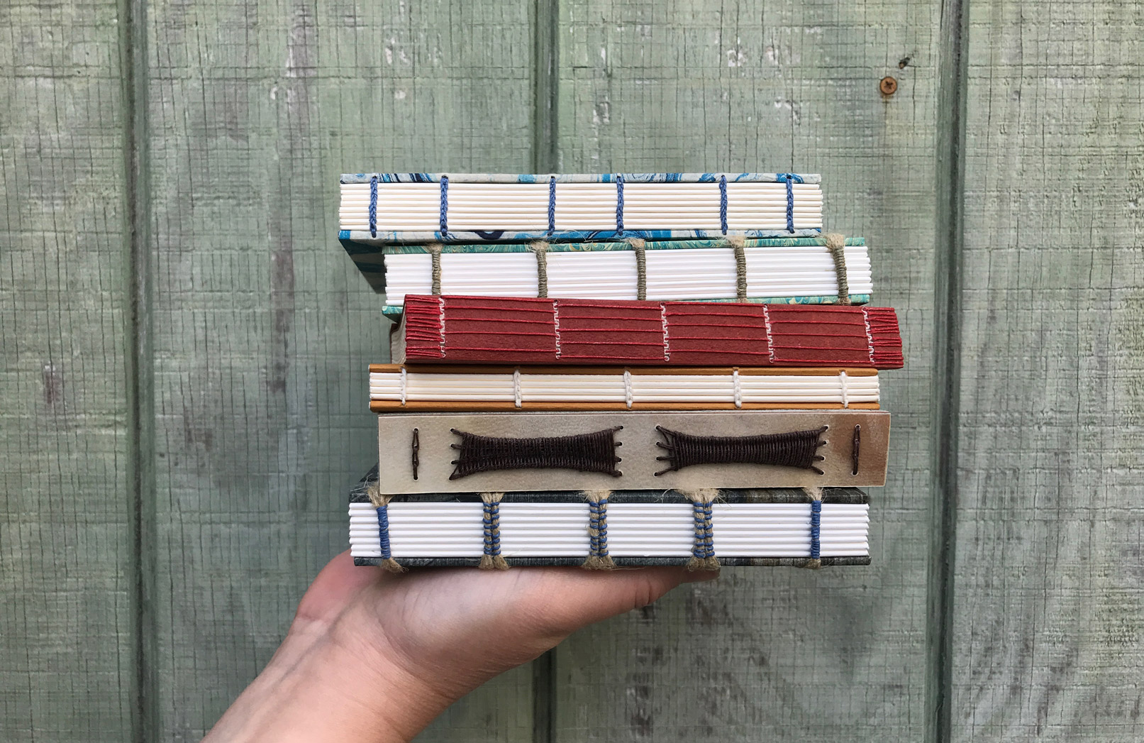 Hand holding a stack of Non-Adhesive Bindings.