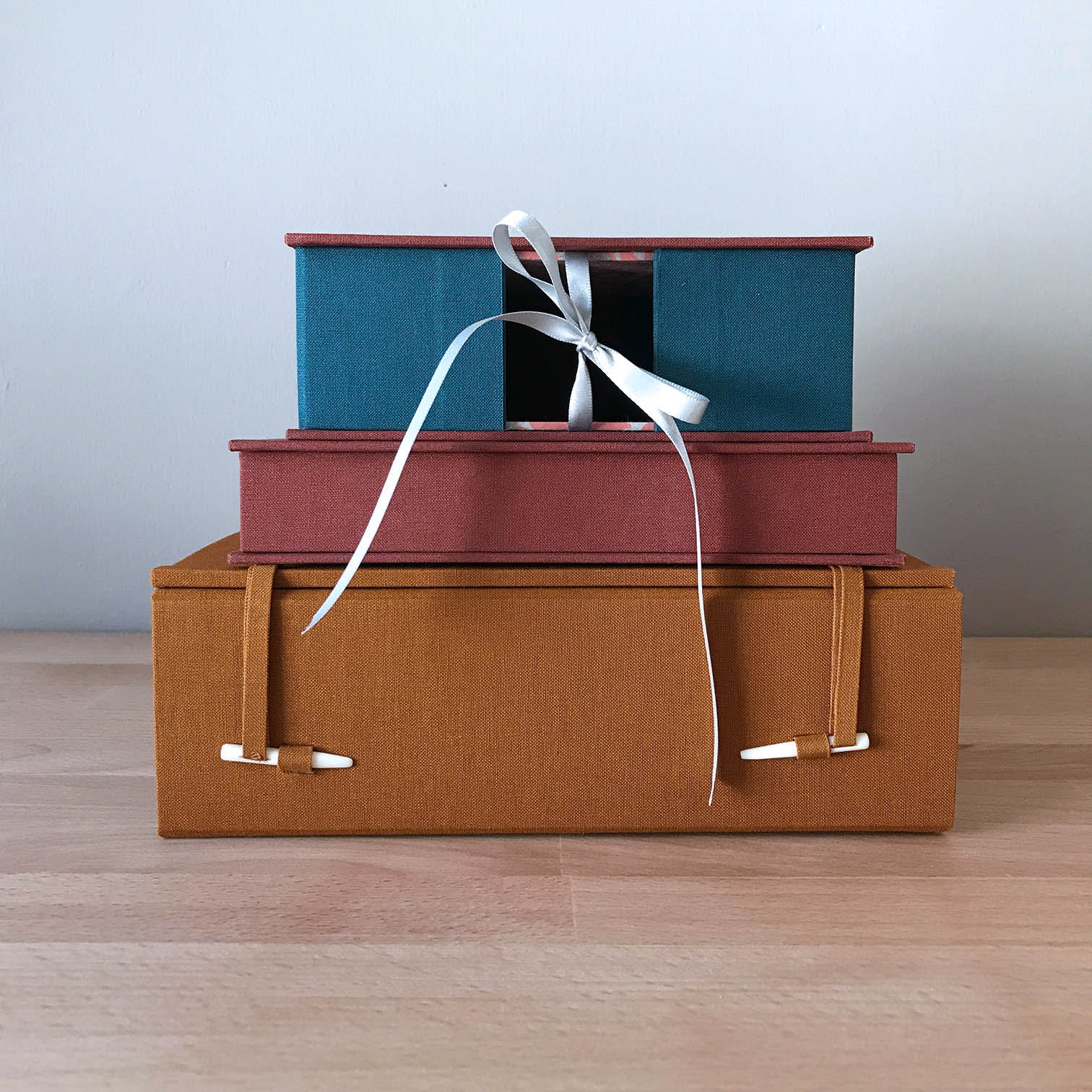 French-Tray with Drop Spine, Clamshell Box, and Japanese Box Case stacked on a wooden table.