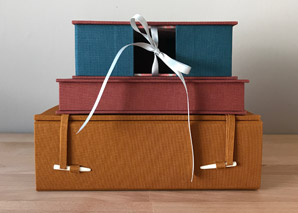 French-Tray with Drop Spine, Clamshell Box, and Japanese Box Case stacked on a wooden table.