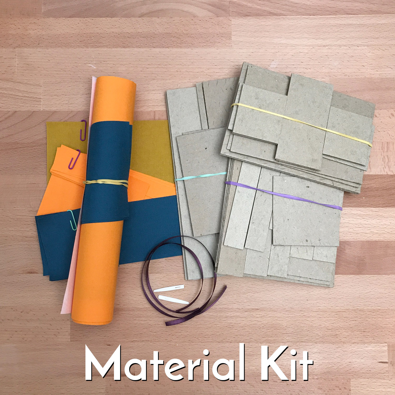 Bookbinding materials for the Box Series workshop sitting on a wooden table.