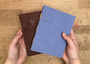 Hands holding two variations of the Cross Structure Binding.