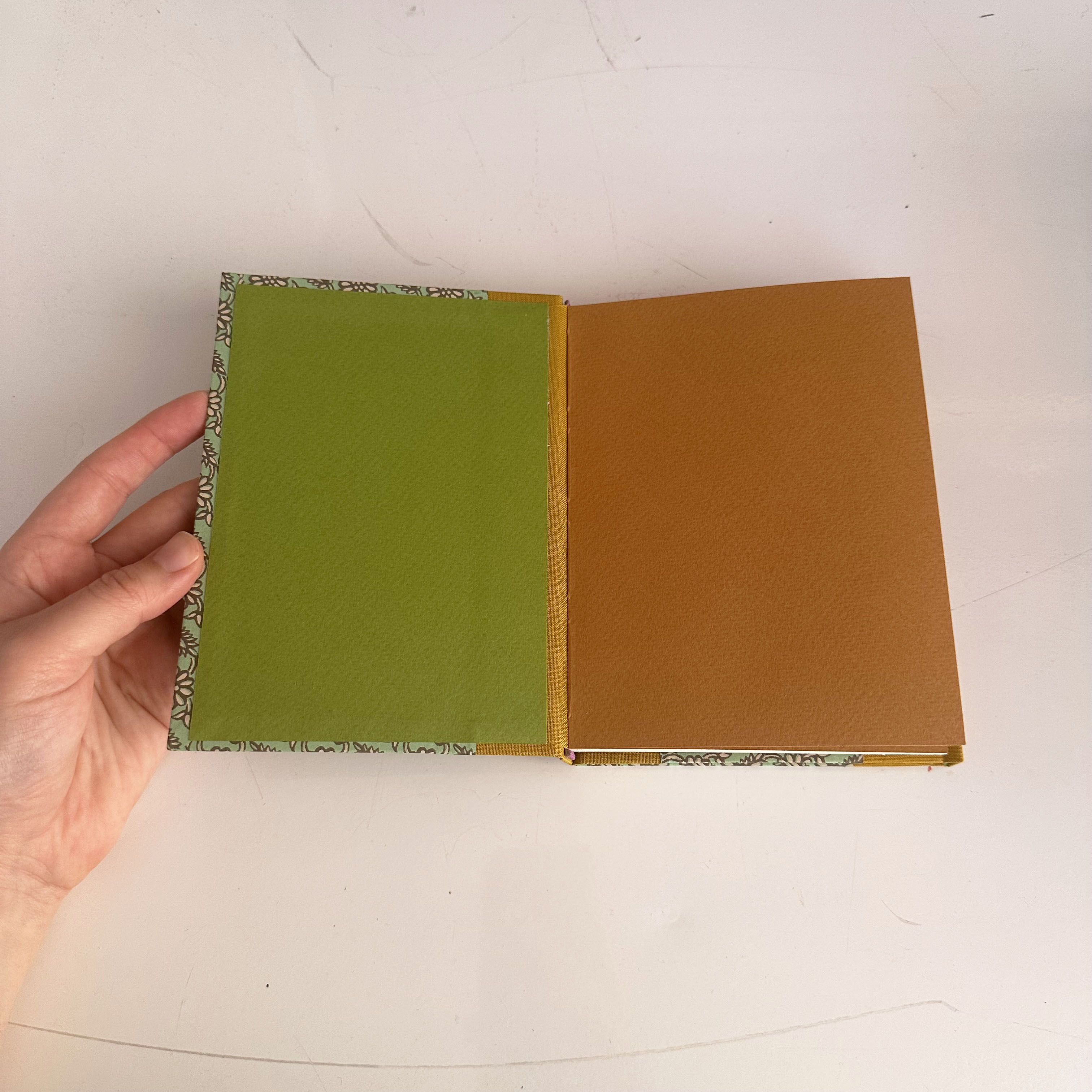 Dos-a-dos binding opened up on a white table.