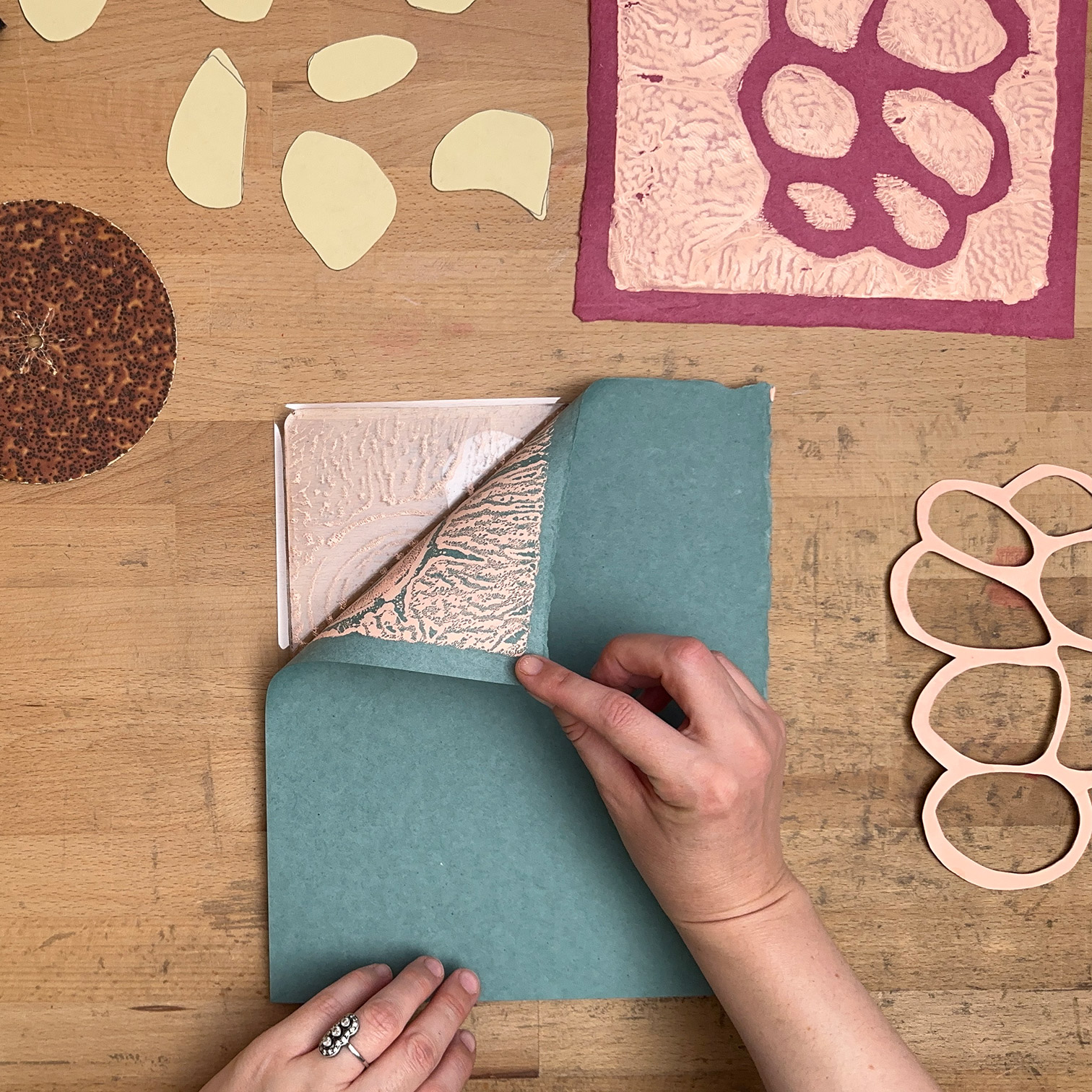Printing set-up showing the action of peeling paper from the Gelli plate to reveal print.