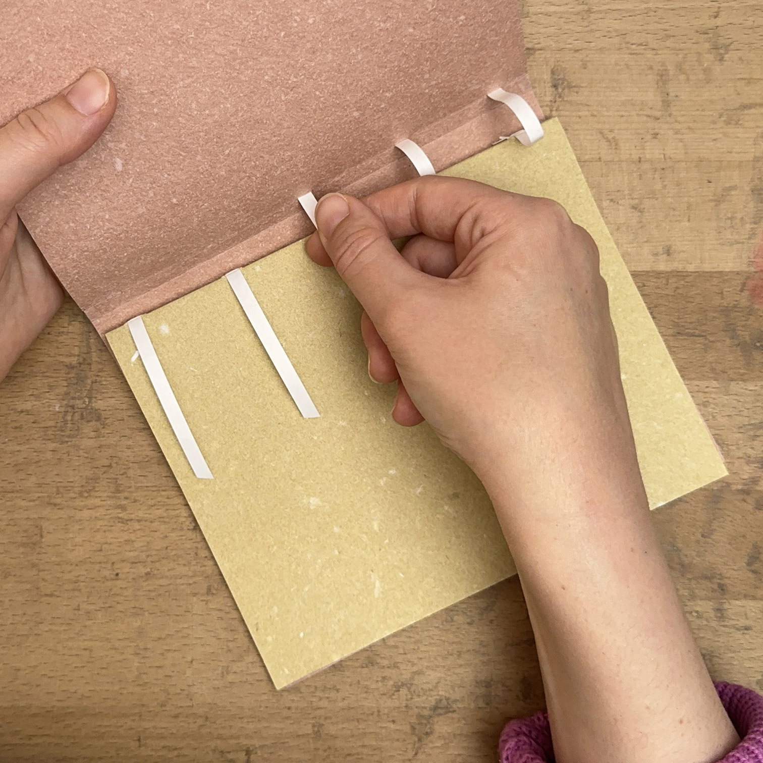 Lacing tapes into interior cover of Envelope Binding.