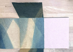 Envelope binding with cover unfolded sitting on a table.