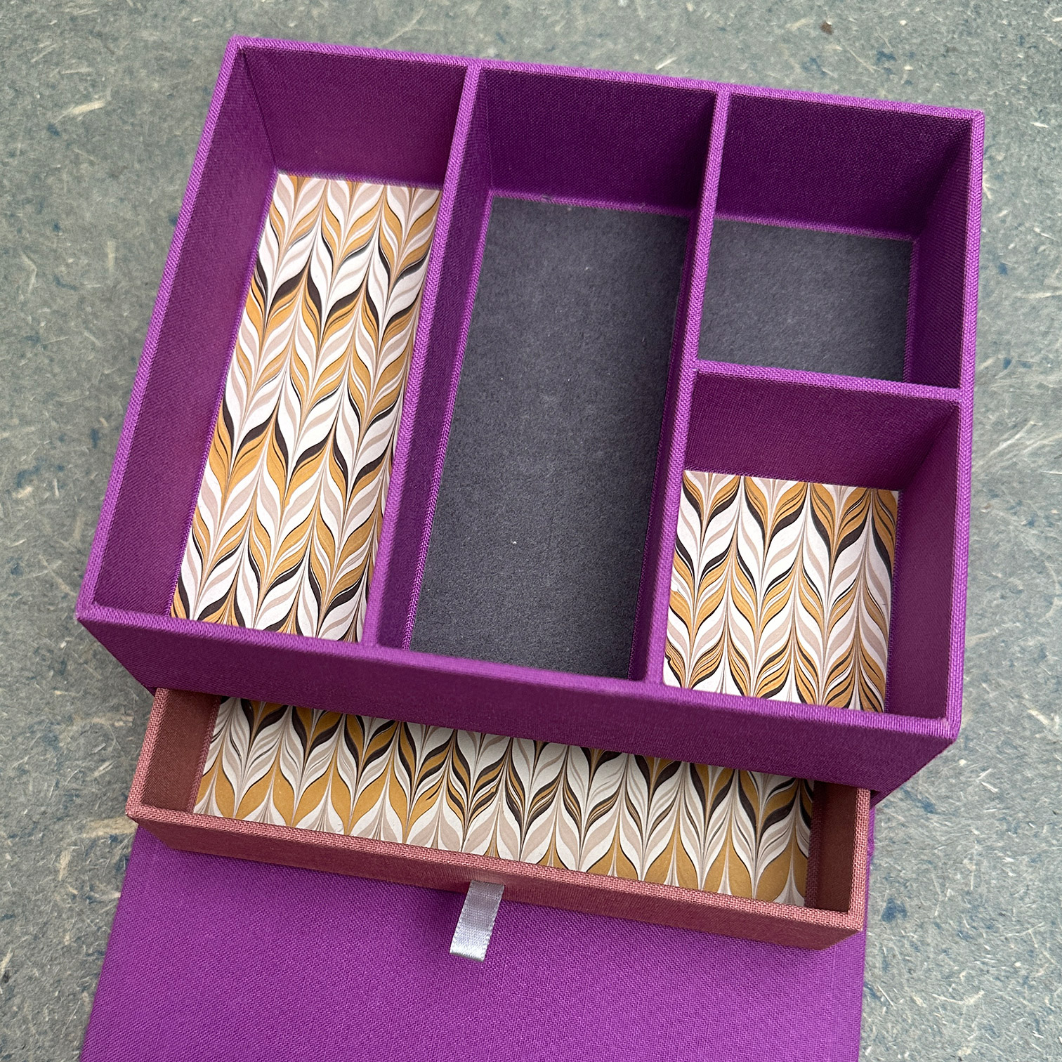 A drawer is opened from underneath the divided compartment.