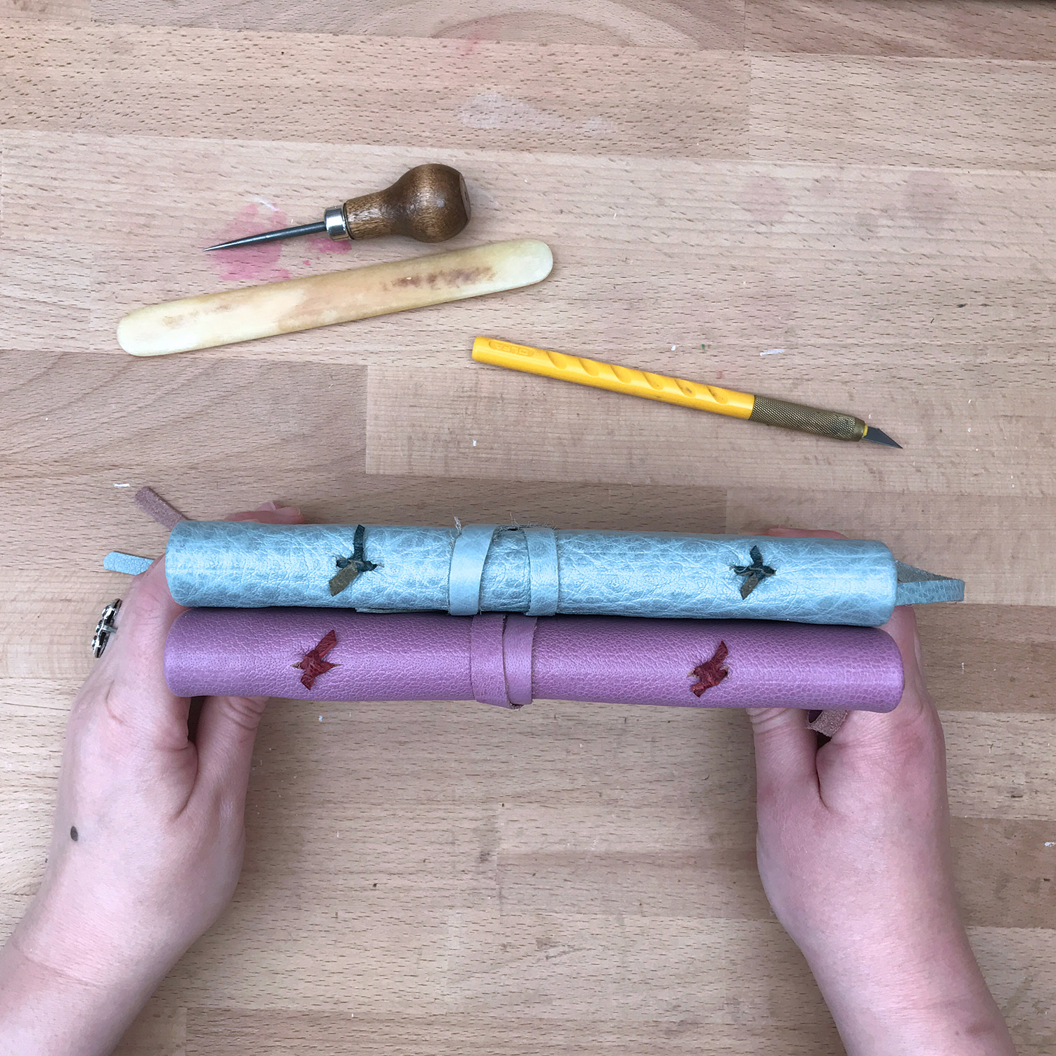 Artist showing the spines of the Modern Nag Hammadi binding.