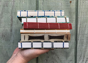 A stack of non-adhesive bindngs held up by a hand.